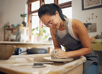 Image showing Clay, happy or creative woman in workshop working on an artistic cup or mug mold in small business. Pottery project, Asian girl or Japanese designer manufacturing handicraft products as entrepreneur