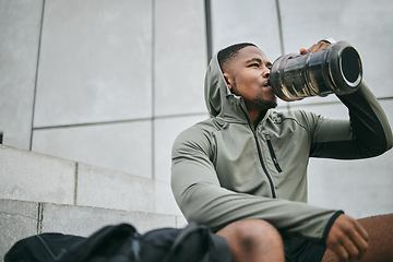 Image showing Fitness, relax or black man drinking water in training or exercise for body recovery or workout in Chicago, USA. Hydration, thirsty or tired healthy sports athlete drinks natural liquid in bottle