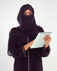 Image showing Portrait, tablet and muslim with a woman in studio on a gray background browsing social media or her news feed. Islam, religion and technology with a female wearing a hijab while surfing the internet