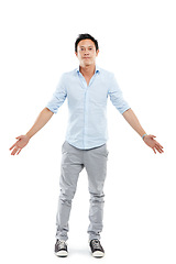 Image showing Man, studio portrait and arms outstretch with fashion, sneakers and edgy jeans by white background. Isolated Asian model, hands open and palm stretching with trendy clothes, style shoes and aesthetic