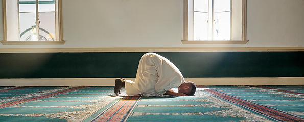 Image showing Mosque, worship and muslim man in prayer on his knees for gratitude, support or ramadan for spiritual wellness. Religion, tradition and islamic guy praying or reciting quran to allah at islam temple.