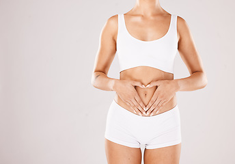 Image showing Health, body and hands in heart of a woman with lose weight results, fitness and beauty goals on studio white background. Underwear, skincare and model woman with gut health, stomach and diet mockup