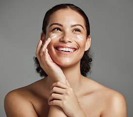 Image showing Skincare, face beauty and woman with cream for acne, dermatology and glow on a studio background. Spa, sunscreen and model thinking of a cosmetics product for dermatology and facial wellness