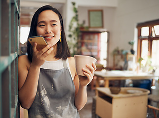 Image showing Pottery, phone call and coffee with an asian woman recording a vote note or message in her workshop. Communication, drink and talking with a female designer or artisan in her studio to design