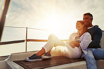 Image showing Hug, sunset and couple on a yacht for travel, retirement holiday and ocean adventure in Spain. Investment, hobby and man and woman on a boat for a luxury cruise, sailing and happiness at sea