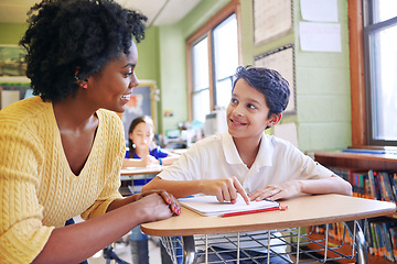 Image showing Learning, education and teacher help student with assignment in elementary school. Classroom support, scholarship and happy black woman or educator aid, explaining or helping male learner in class.