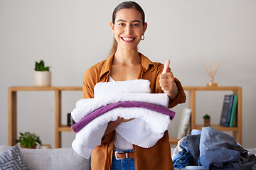 Image showing Thumbs up, laundry and portrait of a woman maid folding clothes in the living room in a modern house. Happy, smile and female cleaner or housewife with a thumbsup cleaning or doing chores in a home.