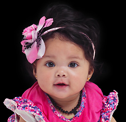 Image showing Portrait, baby or girl with an innocent infant in studio on a black background in floral clothes. Kids, flower and development with a female child on dark space for cute or adorable product placement