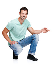 Image showing Portrait, mockup and pointing with a man in studio isolated on a white background for marketing or advertising. Product, branding and mock up with a handsome young male posing to promote a brand