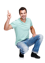 Image showing Portrait, mock up and pointing with a man in studio isolated on a white background for marketing or advertising. Product, branding and mockup with a handsome young male posing to promote a brand