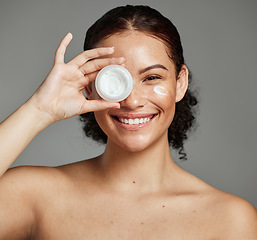 Image showing Black woman, smile portrait and cream for beauty wellness shine, eyes cosmetic dermatology and spa product in grey studio. Happy African girl, facial moisturizer and spf sunscreen or luxury skin glow