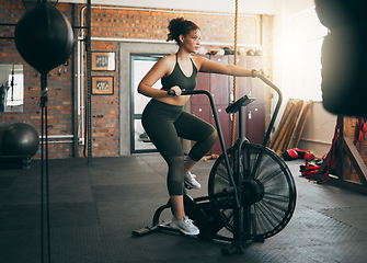 Image showing Fitness, exercise bike and woman at gym for workout, cardio training and cycling for energy, balance and lose weight. Sports female or athlete with spinning machine for health, wellness and self care