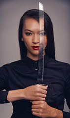 Image showing Portrait, sword and warrior with an asian woman in studio on a gray background for martial arts or combat. Training, fantasy and weapon with a ninja or samurai ready to defend using self discipline