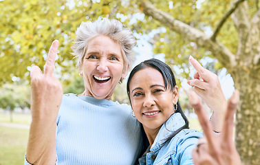 Image showing Senior women, park portrait and hand sign for comic, funny and happy time together in nature. Old woman, friends and hands with peace, middle finger and laughing by trees, nature or forest to relax
