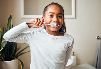 Image showing Girl brushing teeth, portrait and toothbrush for hygiene with clean mouth and fresh breath with dental health. Kid, cleaning with toothpaste in bathroom and wellness at family home with healthy gums