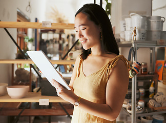 Image showing Asian creative business woman, tablet and smile for social media, communication or networking at workshop. Happy Japanese female smiling holding touchscreen for pottery art, inventory or startup