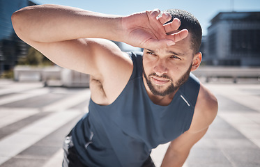 Image showing Fitness, man and relaxing on break from workout, training or exercise in the city for healthy recovery in the outdoors. Sporty male breathing feeling tired, exhausted or drained after running cardio