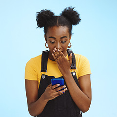 Image showing Wow, gossip and shocked black woman isolated on blue background for social media, fake news or post update. Smartphone, surprise notification and people, gen z or person reading text in studio mockup