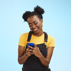 Image showing Black woman with smartphone in hands, smile and happy with chat or social media, communication isolated on blue background. Technology, happiness and gen z youth, phone with internet wifi and mockup