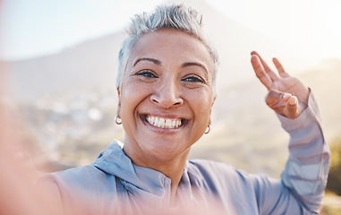 Image showing Elderly woman runner, exercise selfie and smile in nature for fitness, wellness or self care with OK hand sign. Happy senior black woman, profile picture and running by mountains, outdoor and workout