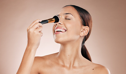 Image showing Makeup, brush on face and woman with beauty cosmetics mockup and wellness against studio background. Facial, treatment and cosmetic equipment, smile and foundation application with tools and skincare