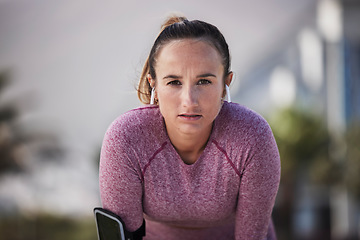 Image showing Woman runner portrait, music and earphones for motivation, outdoor workout or fitness in city. Girl, wellness and focus on face with phone, streaming online or run for training, exercise or health