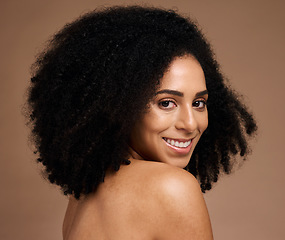 Image showing Black woman, studio portrait and beauty with smile, cosmetic glow and healthy with afro by backdrop. Model, skincare and natural hair care for aesthetic, wellness and self care by brown background