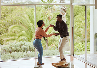 Image showing Black couple, dancing and celebration in their new home with love while excited and happy in a healthy marriage. Young man and woman partner dance to celebrate in their house or apartment for fun