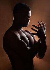 Image showing Black man, muscle and dark studio with silhouette, hands and sign for art deco vision, beauty and shadow. Man, art aesthetic and smoke with strong body, alone and struggle with mental health problem