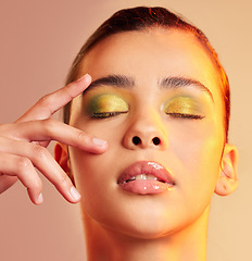 Image showing .Face, beauty and makeup with a model woman in studio on a bright color background for cosmetics are treatment. Cosmetic, art and a beautiful young female touching her soft skin with her hand.