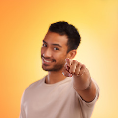 Image showing Man, point and happy portrait of a person with a hand sign with orange studio background. Smile, isolated and model with blur mock up space and hands and finger gesture zoom smiling alone with beard