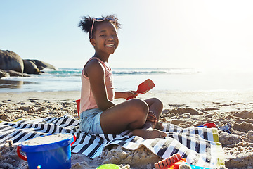 Image showing Black child, smile and playing with sand at the beach for summer vacation, holiday or weekend in the outdoors. Portrait of happy African American little girl enjoying fun time with toys by the ocean