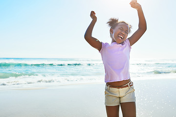 Image showing Children, beach and fun with a black girl dancing alone on the sand in summer by the sea or ocean. Nature, kids and blue sky with a female child playing by the water while on holiday or vacation