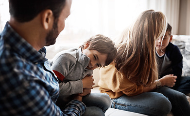 Image showing Family, children and a father tickling his son in the living room of their home together with mom and brother in the background. Playful, relax or love with a man, woman and kids bonding in a house