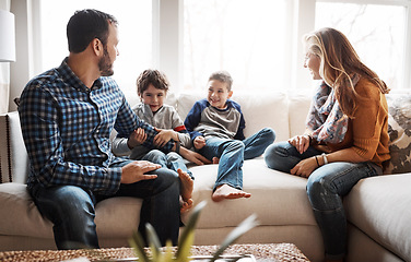 Image showing Family home, boy kids and parents on sofa with conversation, love or bonding for childhood development. Happy family, relax and sitting together in home living room for fun, happiness or quality time