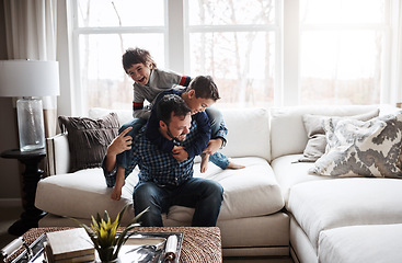 Image showing Playful, bonding and father with children on the sofa for playing, quality time and crazy fun. Love, happy and boy kids piling onto their dad with energy on the couch of their family home together