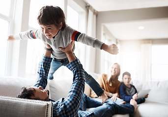 Image showing Wellness, relax and father lifting child on sofa for bonding, fun and play in happy home. Dad playing flying plane in air game with son on living room couch for care, love and bond together