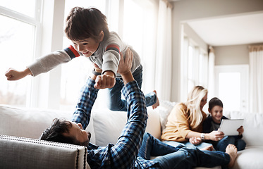 Image showing Family, father and lifting child on sofa for bonding, wellness and play in happy home. Dad playing flying plane in air game with son on living room couch for care, love and bond together