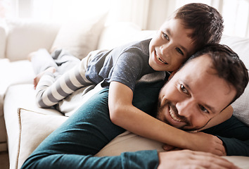 Image showing Hug, fun and child playing with father on the living room sofa to relax in their family home. Happy, funny and dad and boy kid with playful affection while smiling on the couch in the lounge