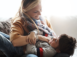 Image showing Mother, child and tickling while together in happy family home with love, care and happiness. Funny woman playing with kid on living room sofa for bonding, energy and quality time at their house