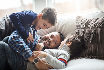 Image showing Love, father and boys playing, sofa and bonding on weekend, loving or quality time together. Family, dad and male children being playful, relax or happiness on break, lounge or kids cheerful on couch