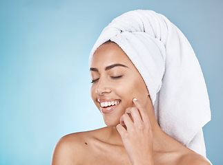 Image showing Woman, face and happy skincare with towel for luxury beauty, salon spa cleaning and closed eyes in blue background studio. Happy model, smile and skin glow, facial wellness or hair care dermatology