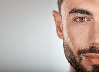 Image showing Face, beauty and eye of a man with clean, glow and healthy skin on a grey studio background for dermatology skincare. Portrait of a male with facial cosmetics for self care with marketing free space