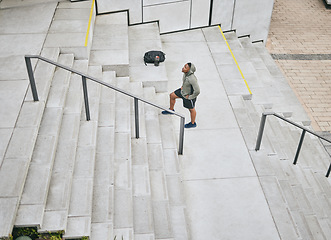 Image showing Fitness, tired or black man walking on stairs for training, exercise or cardio workout in Chicago, USA. Mission, mindset or healthy athlete in hoodie thinking of sports goals or breathing on steps