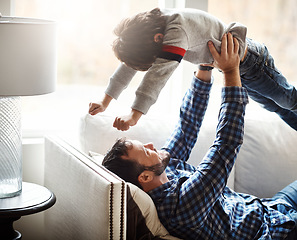 Image showing Happy, father and lifting kid on home sofa for bonding, wellness and play together with smile. Dad playing flying in air game with son on living room couch for care, love and bond in family home