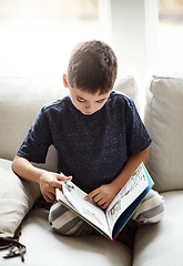 Image showing Hobby, boy and reading on sofa, relax and happy on weekend, break and learning. Male child, kid and book for fun, education and story time on couch in living room, happiness and child development