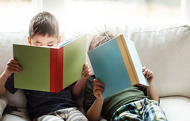 Image showing Children, bonding and reading books for education, learning or relax studying on house living room in family home sofa. Kids, brothers and boys with storytelling, fairytale novels or fantasy fiction