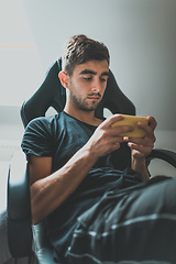 Image showing casual man holding and using smartphone