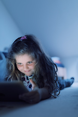 Image showing Little Girl watching movie On A Digital Tablet