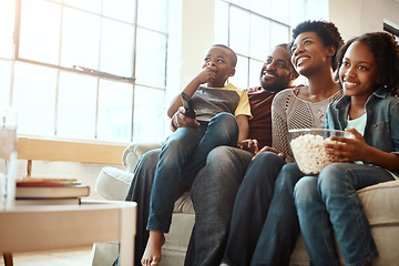 Image showing Happy black family on sofa for movie, television or film together, bonding and quality time in living room. Popcorn, kids TV show and people, mother and father with kids, sitting on couch watching